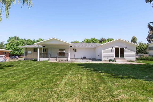 Back of property featuring entry steps, a lawn, a porch, and roof with shingles | Image 6