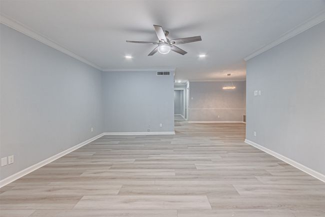 Empty room featuring ornamental molding, light wood-type flooring, and ceiling fan | Image 35