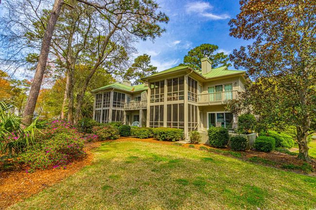 Rear view of house with a lawn, a chimney, and a sunroom | Image 36