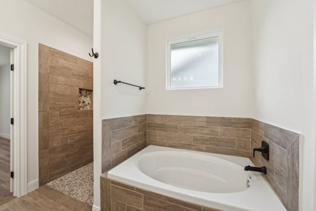 Bathroom featuring a bath, wood plant Tile floors, and a tile shower | Image 24
