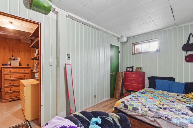 Bedroom featuring light wood finished floors and wood walls | Image 26