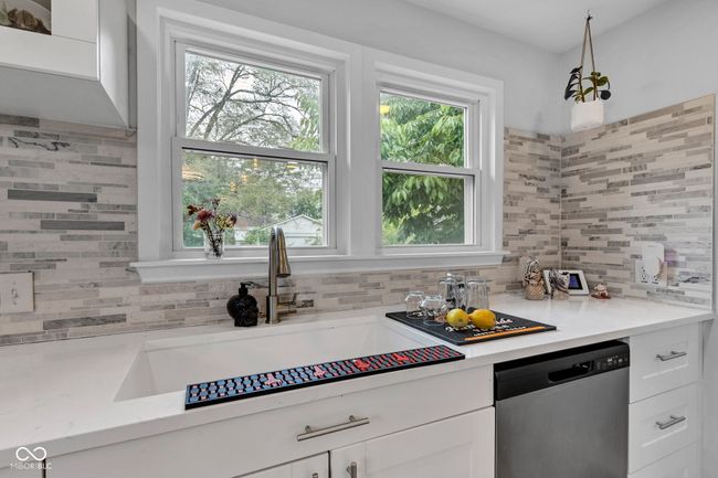 kitchen featuring stainless steel dishwasher, a sink, and backsplash | Image 14