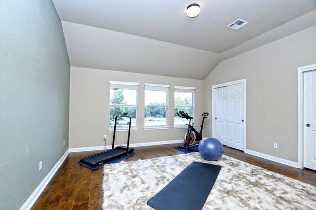 Workout room featuring vaulted ceiling, dark wood-style flooring, and baseboards | Image 15