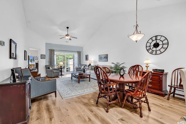 Dining area with high vaulted ceiling, light wood-style flooring, and ceiling fan | Image 10