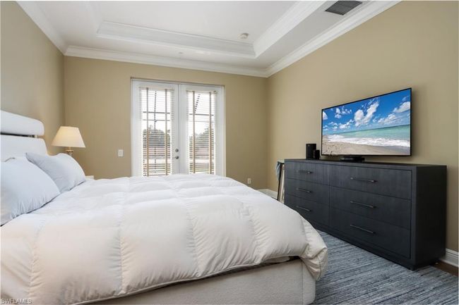 Bedroom featuring a tray ceiling, access to exterior, ornamental molding, and french doors | Image 10