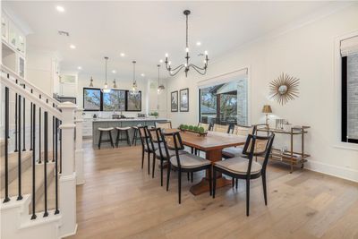 The wide-plank wood floors give this open concept space warmth, as do the more traditional moldings and finishes. This is a newer construction home, that has barely been lived in since the owners live primarily elsewhere. | Image 1