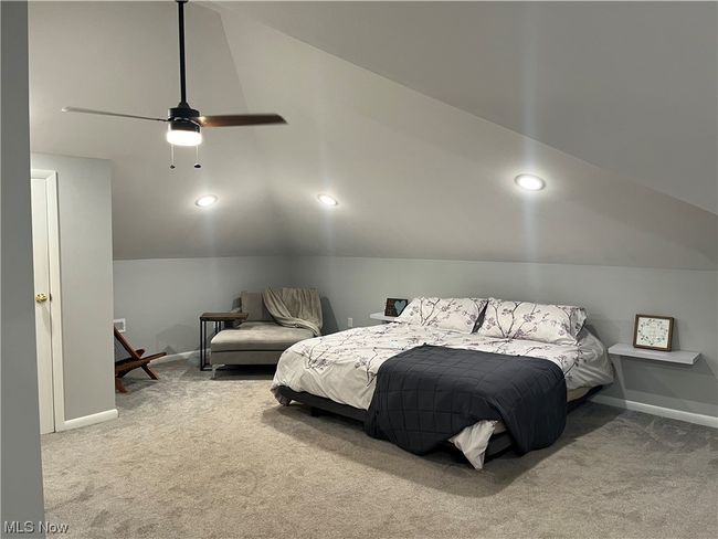 Bedroom with vaulted ceiling, carpet floors, and ceiling fan | Image 23