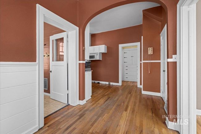 Hallway featuring arched walkways and light wood-style floors | Image 19