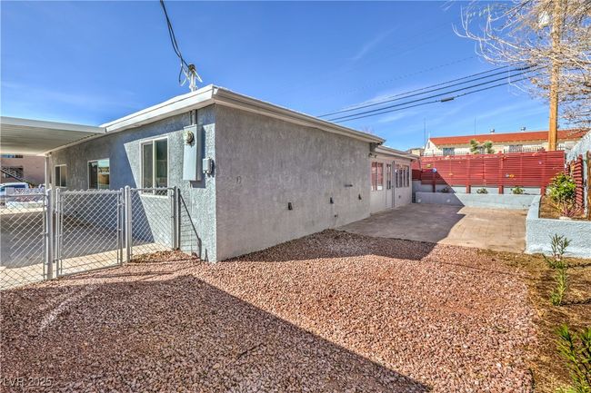 View of side of property featuring a patio, fence, a gate, and stucco siding | Image 37