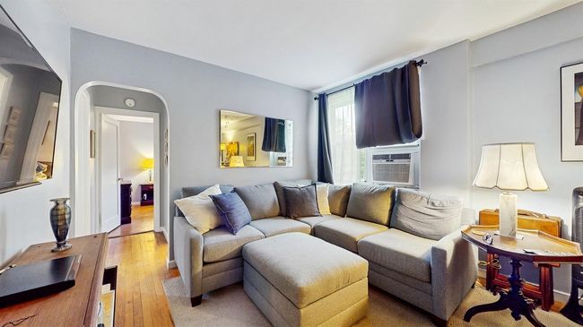 Living area with arched walkways, light wood-type flooring, and cooling unit | Image 6