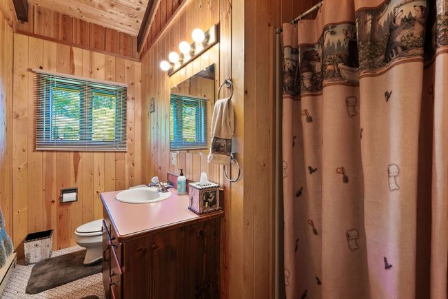 Bathroom with vanity, wood walls, a shower with shower curtain, and wood ceiling | Image 12