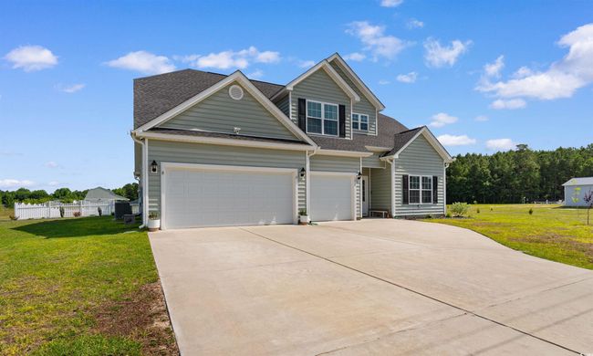View of front of house featuring a shingled roof, driveway, and a garage | Image 39