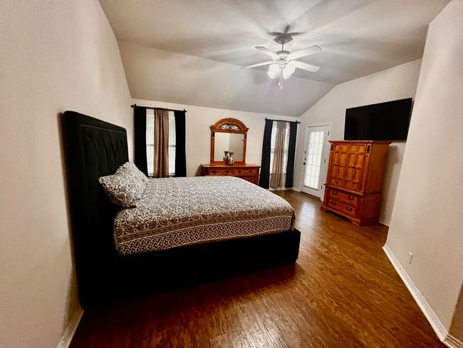 Bedroom featuring lofted ceiling, wood finished floors, and a ceiling fan | Image 11