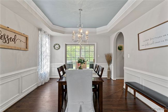 Dining space with an inviting chandelier, a raised ceiling, dark wood-type flooring, a decorative wall, and arched​​‌​​​​‌​​‌‌​‌‌​​​‌‌​​‌‌​‌​​​​​‌ walkways | Image 21