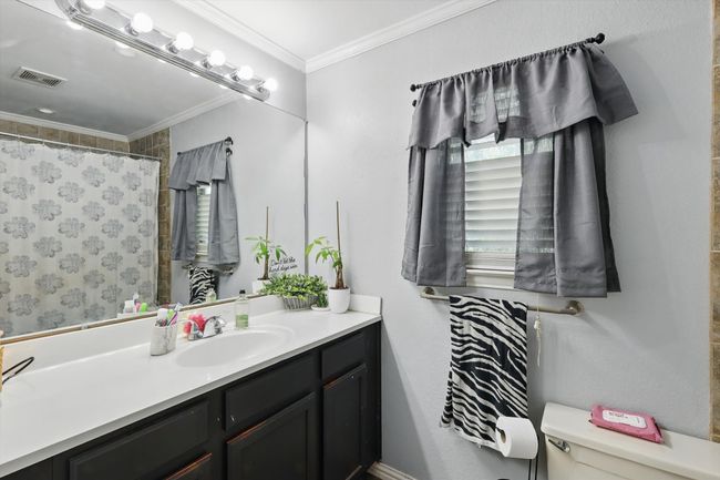 Full bathroom with vanity, crown molding, and curtained shower | Image 19