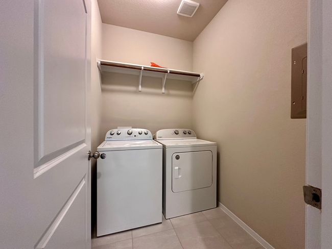 Laundry room with washing machine and dryer, light tile patterned flooring, and electric panel | Image 19