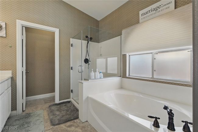 Bathroom with baseboards, a bath, vanity, and a stall shower | Image 21