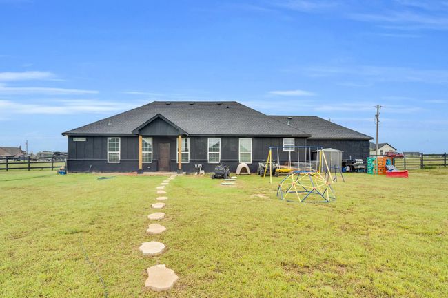 Rear view of house with roof with shingles and a playground | Image 24