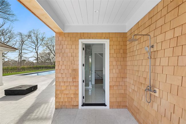 Outdoor shower & entrance to main floor full bath/changing off pool area | Image 34