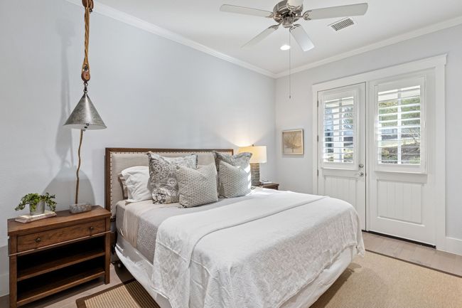 Bedroom with ceiling fan, visible vents, light wood-style floors, and crown molding | Image 18