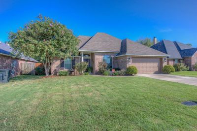 Single story home with a garage and a front lawn | Image 1