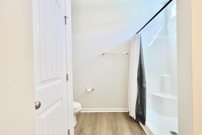 Full bathroom with wood finished floors and a shower with curtain | Image 15