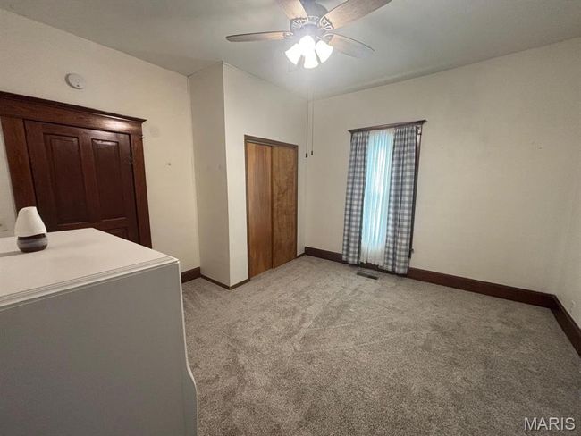 Bedroom with light carpet, a ceiling fan, and a closet | Image 20