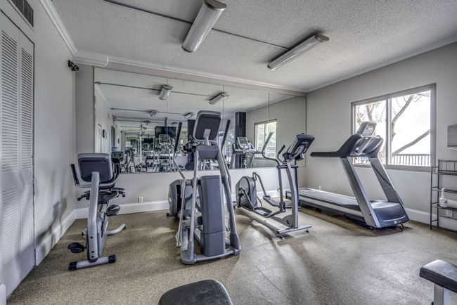 Included in the HOA fee, the exercise room is exclusively available for residents and is equipped with treadmills, elliptical machines, weights, and other fitness amenities. | Image 37