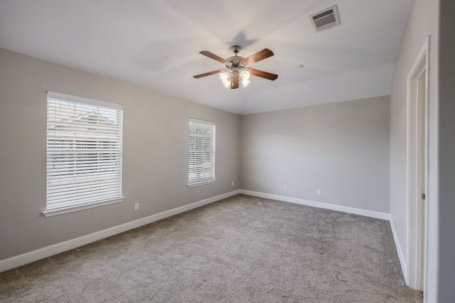 Carpet in the Primary bedroom featuring ceiling fan | Image 11