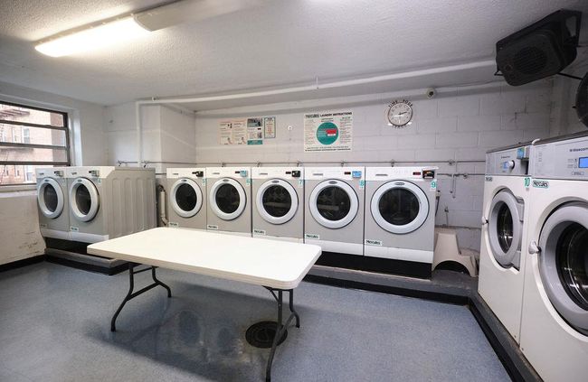 Common laundry area with concrete block wall, independent washer and dryer, and a textured ceiling | Image 12