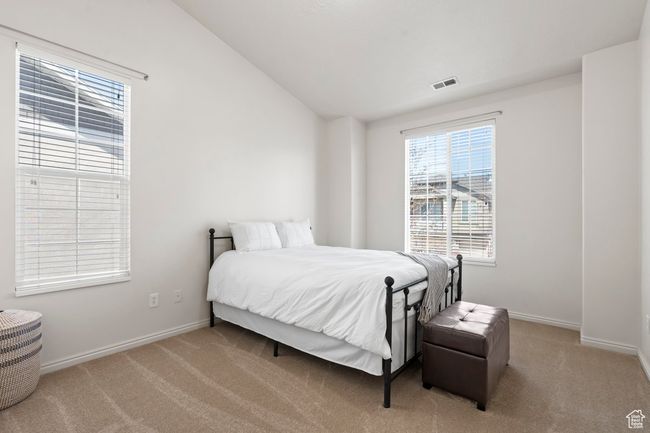 Bedroom with visible vents, carpet flooring, baseboards, and vaulted ceiling | Image 8