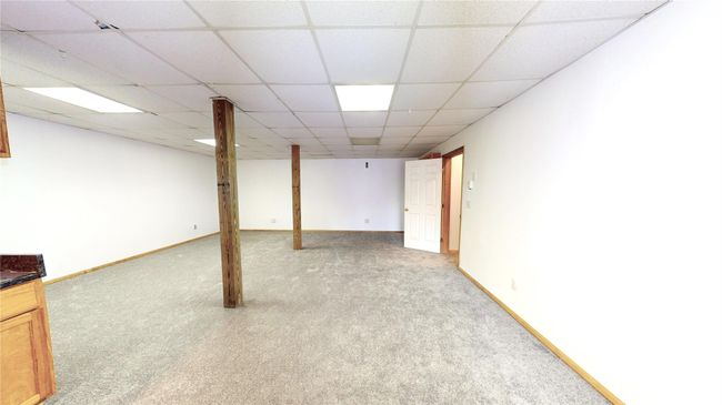 Finished basement featuring a paneled ceiling, baseboards, and carpet flooring | Image 27
