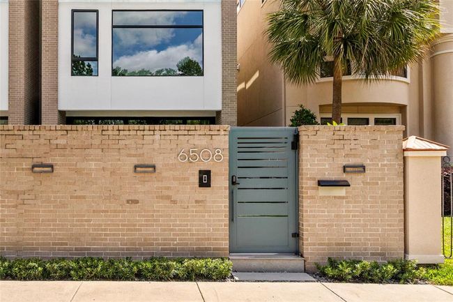 The gated entry at 6508 is perfect for a lock & leave lifestyle and makes a bold first impression with its modern steel door, warm brick privacy wall, and sleek house numbers. Clean lines and contemporary lighting create a sophisticated welcome, setting the tone for the stylish design found beyond the gate. | Image 35