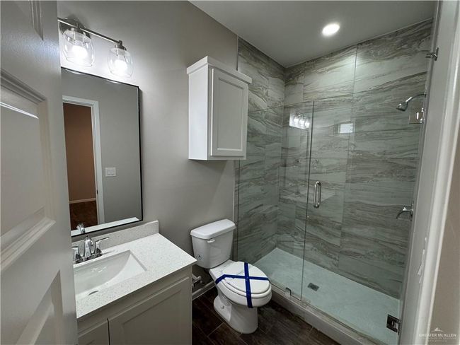 Bathroom featuring toilet, a shower stall, vanity, and wood finished floors | Image 17