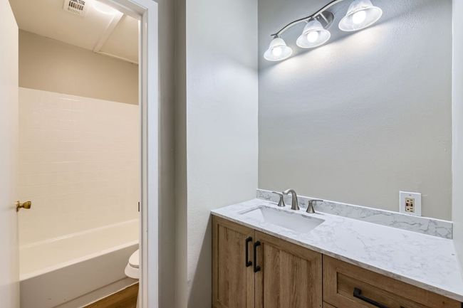 Bathroom featuring visible vents, toilet, and vanity | Image 12