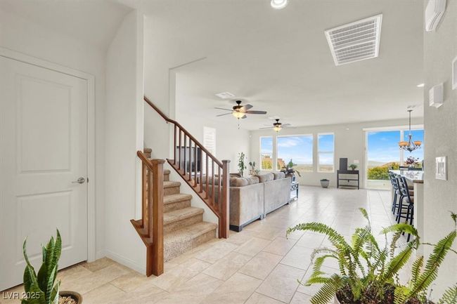 Living area with stairs, a chandelier, and a ceiling fan | Image 11