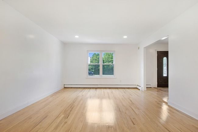 Spare room with baseboard heating, light wood-type flooring, baseboards, and recessed lighting | Image 6