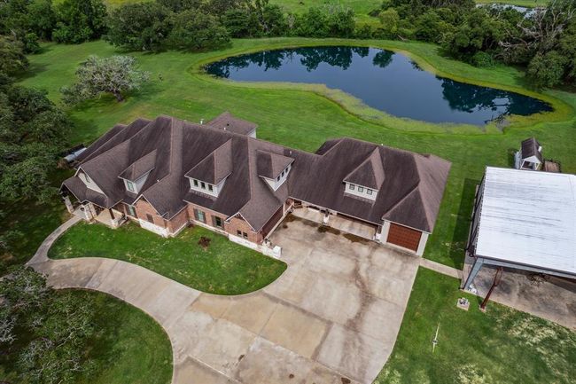 This custom home is designed with both luxury and practicality in mind, featuring an attached two-car garage, an oversized three-car tandem garage, and a massive 16' x 50' RV/boat garage with a 12' x 12' overhead door. A charming porte cochere adds to the home’s elegance, while two covered front patios provide ideal spaces to relax and enjoy the outdoors. This home is perfect for those seeking ample storage and easy access for vehicles, boats, or RVs. | Image 45