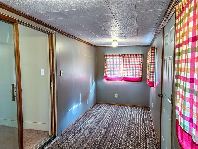 Empty room with carpet, baseboards, and crown molding | Image 6