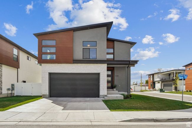 Modern home with a gate, driveway, an attached garage, a front yard, and stucco siding | Image 31