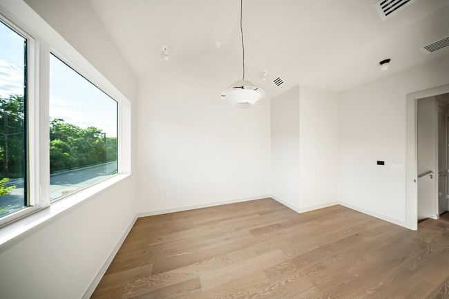 Unfurnished room with wood finished floors, vaulted ceiling, and baseboards | Image 16