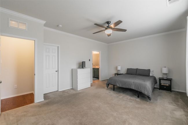 Carpeted Main bedroom featuring ensuite bathroom, crown molding, and ceiling fan | Image 27