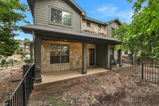 Rear view of property with stone siding, roof with shingles, and covered porch | Image 25