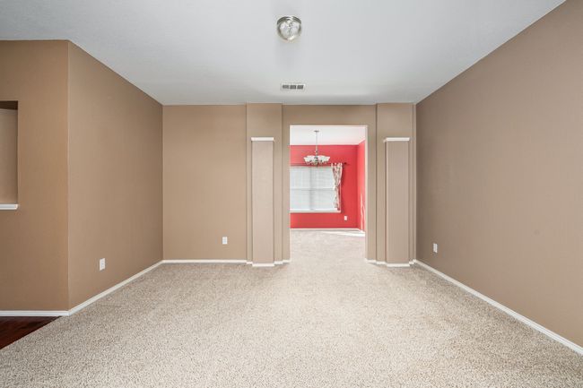 Unfurnished room with a chandelier and carpet floors | Image 4