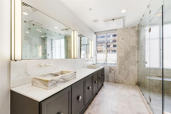 Stunning primary bath with dual vanities and marble vessel sinks. | Image 21