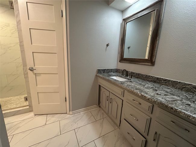 Full bathroom with marble look tile flooring, vanity, and a stall shower | Image 23