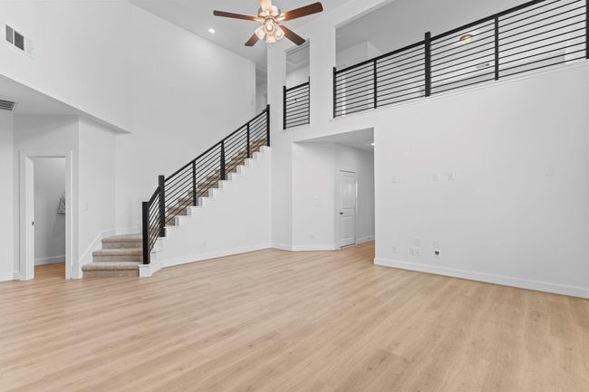 Modern wrought iron railing lines the sweeping staircase that curves gracefully from the main living space, drawing your eye upward and adding a sophisticated touch to the home’s open design. **Image Representative of Plan Only and May Vary as Built**. | Image 16
