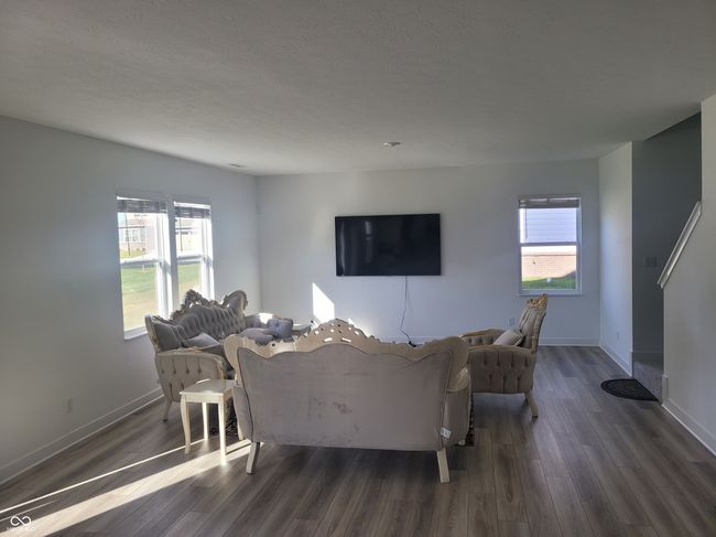 living area featuring dark wood-style flooring and plenty of natural light | Image 6
