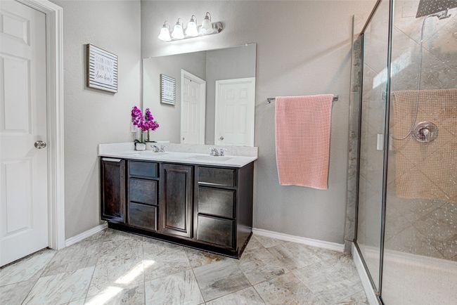 Bathroom with a sink, a shower stall, and double vanity | Image 14