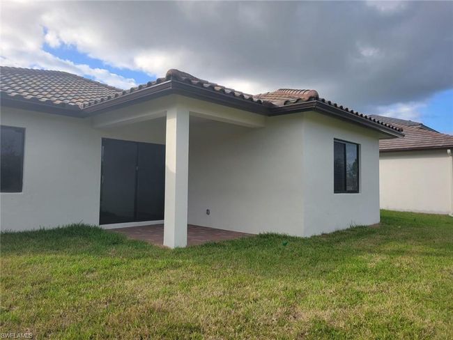 Back of house featuring a lawn, a patio, stucco siding, and a tile roof | Image 33